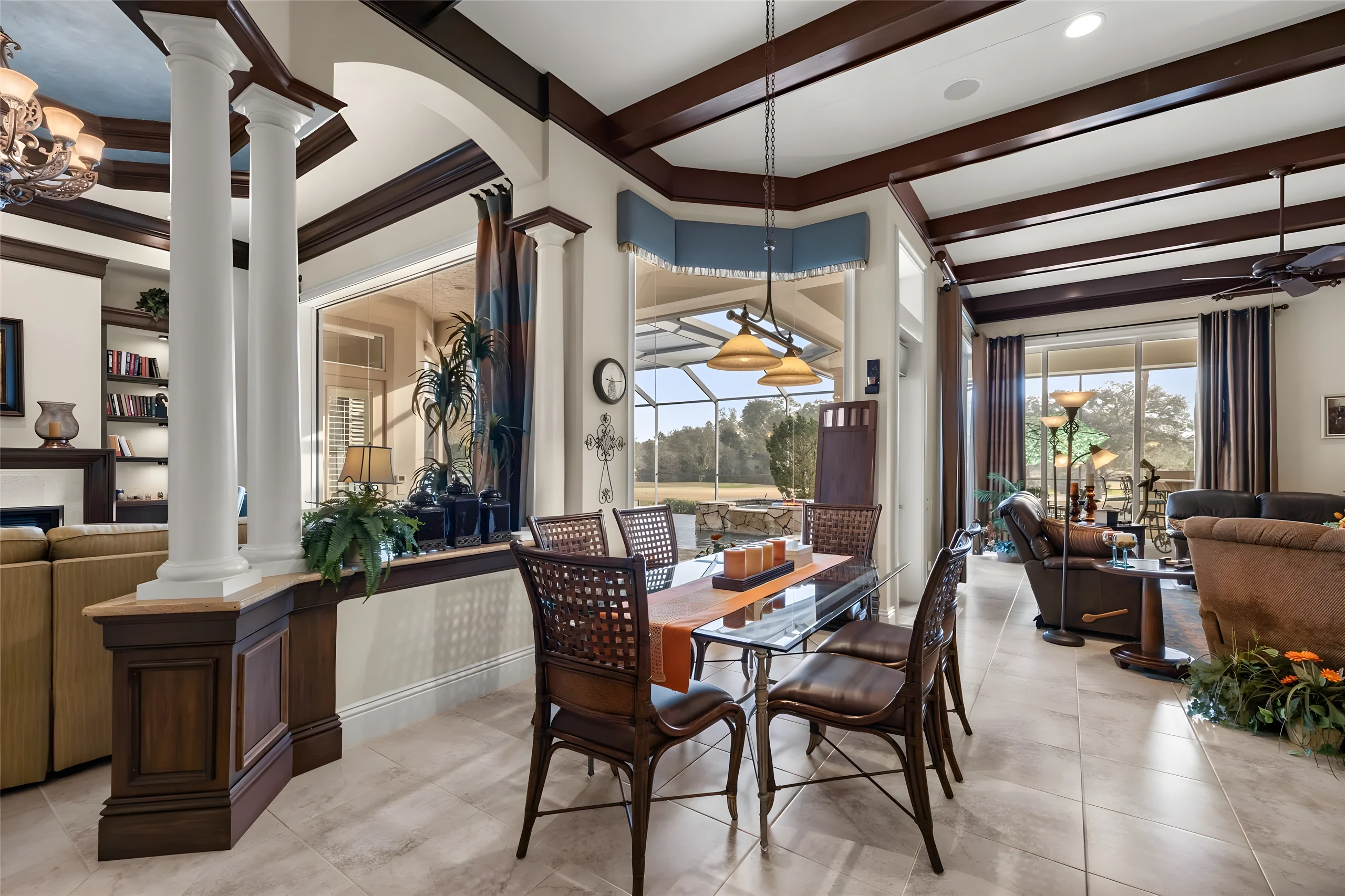 Breakfast area between the kitchen and the family room, with a glass table and windows onto the lanai