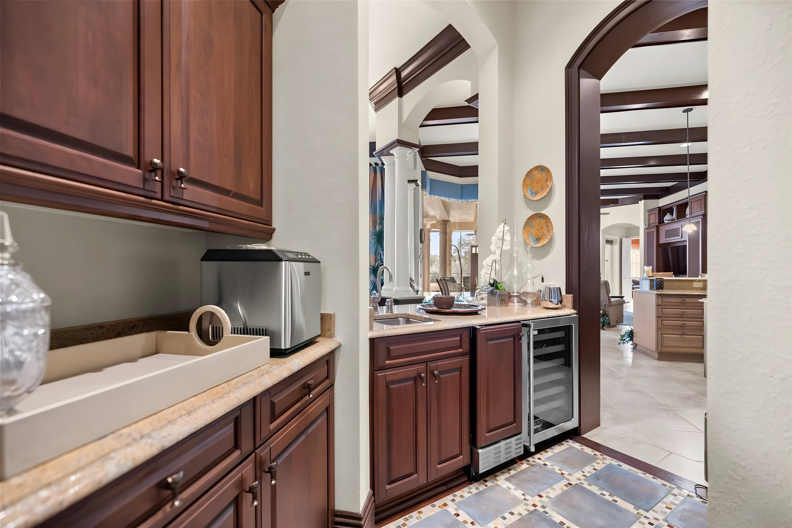 Wet bar and butler’s pantry with a wine cooler, sink and ice maker, between the kitchen and the dining room