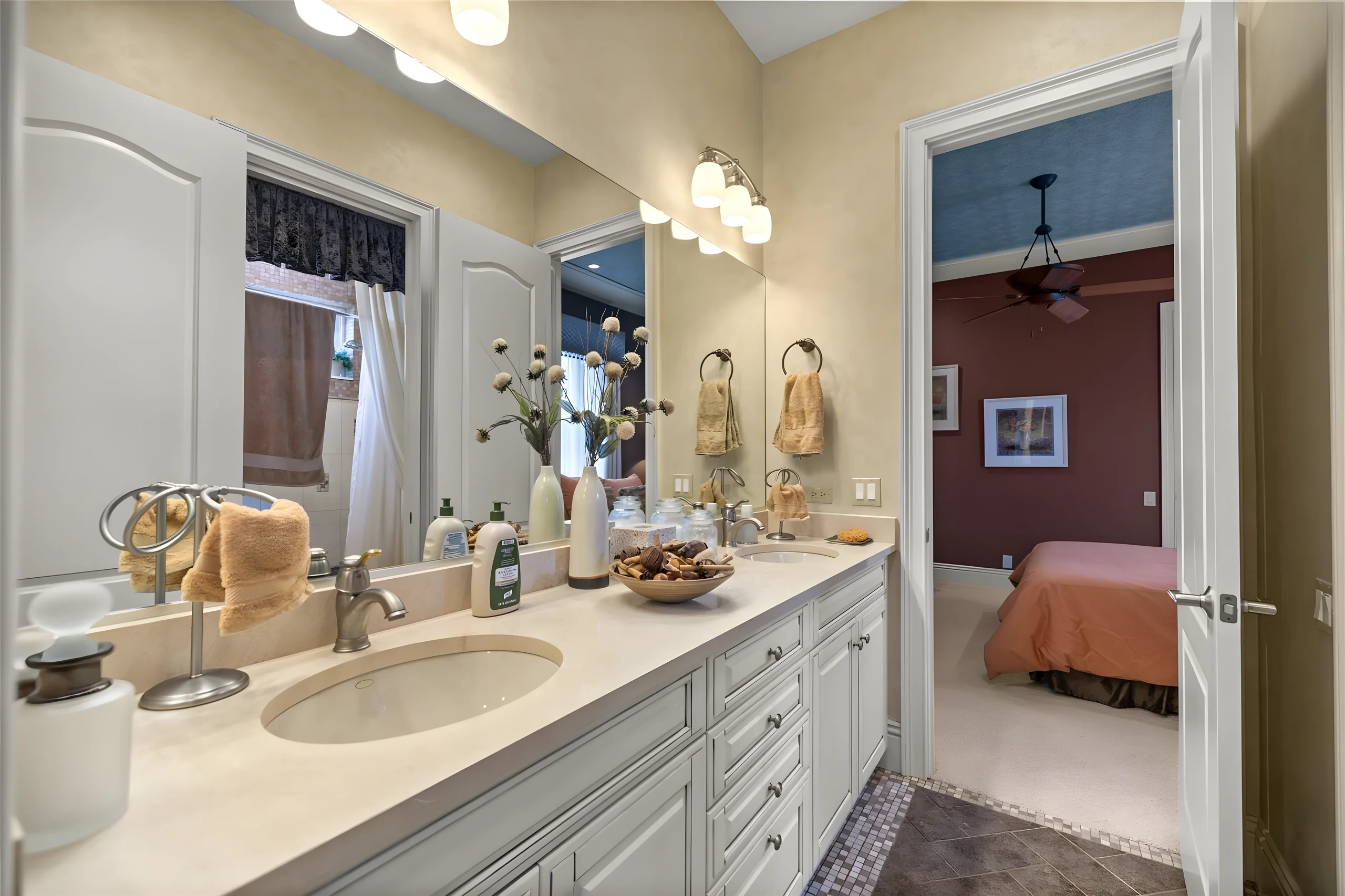 Jack and Jill bathroom vanity with a long mirror and a door through to a bedroom