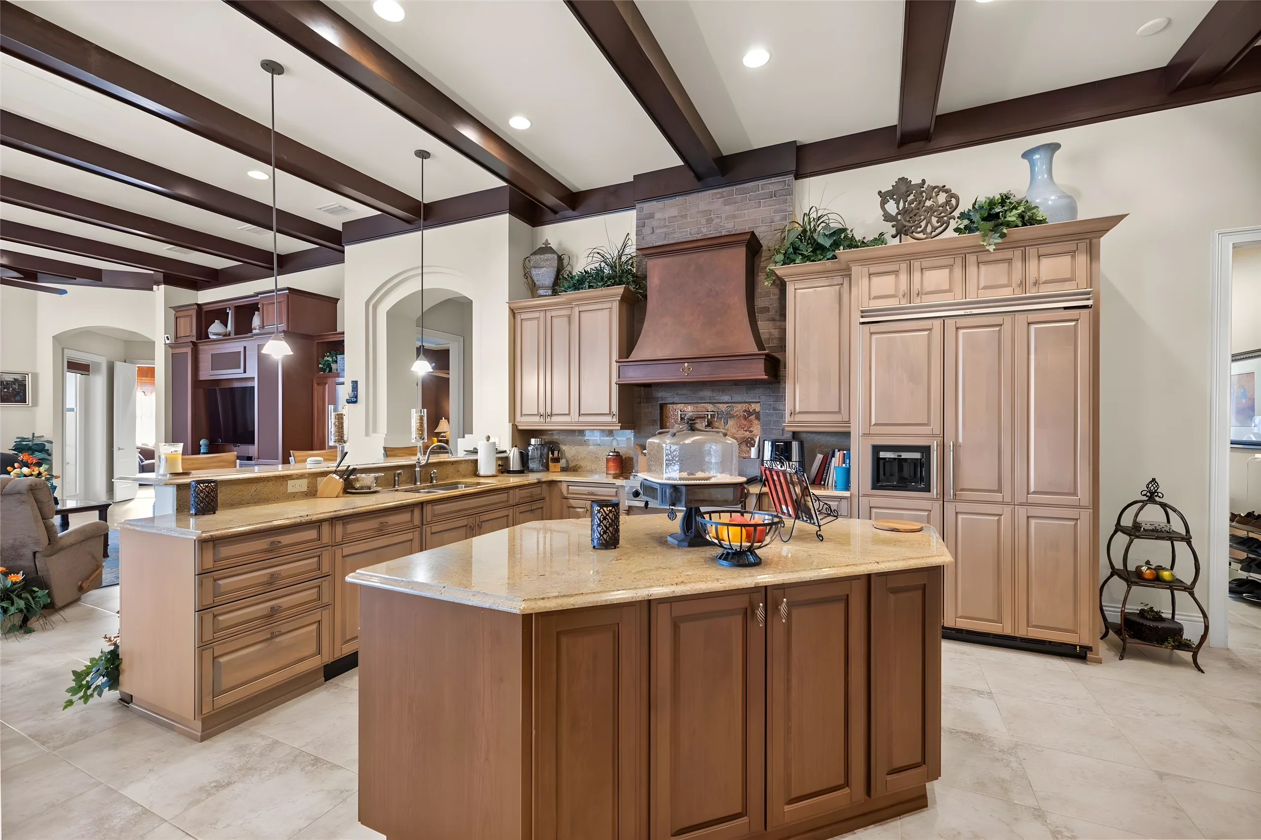 Kitchen island and wood cabinetry, with the paneled refrigerator and the copper hood