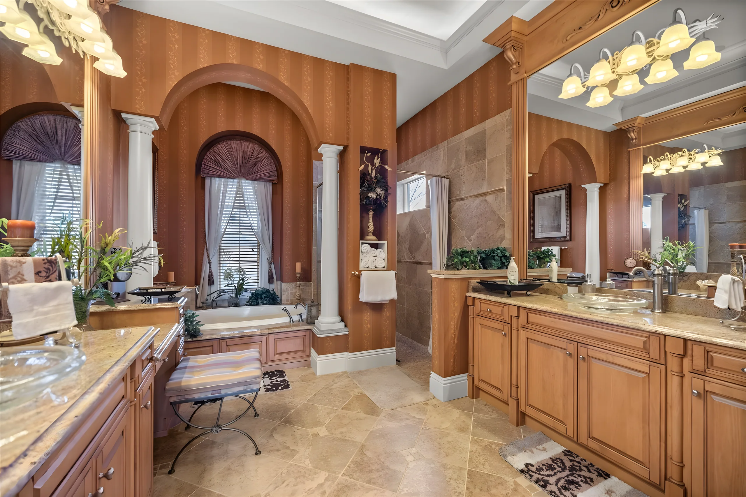Master bathroom with arched windows, columns, a jetted tub and two vanities