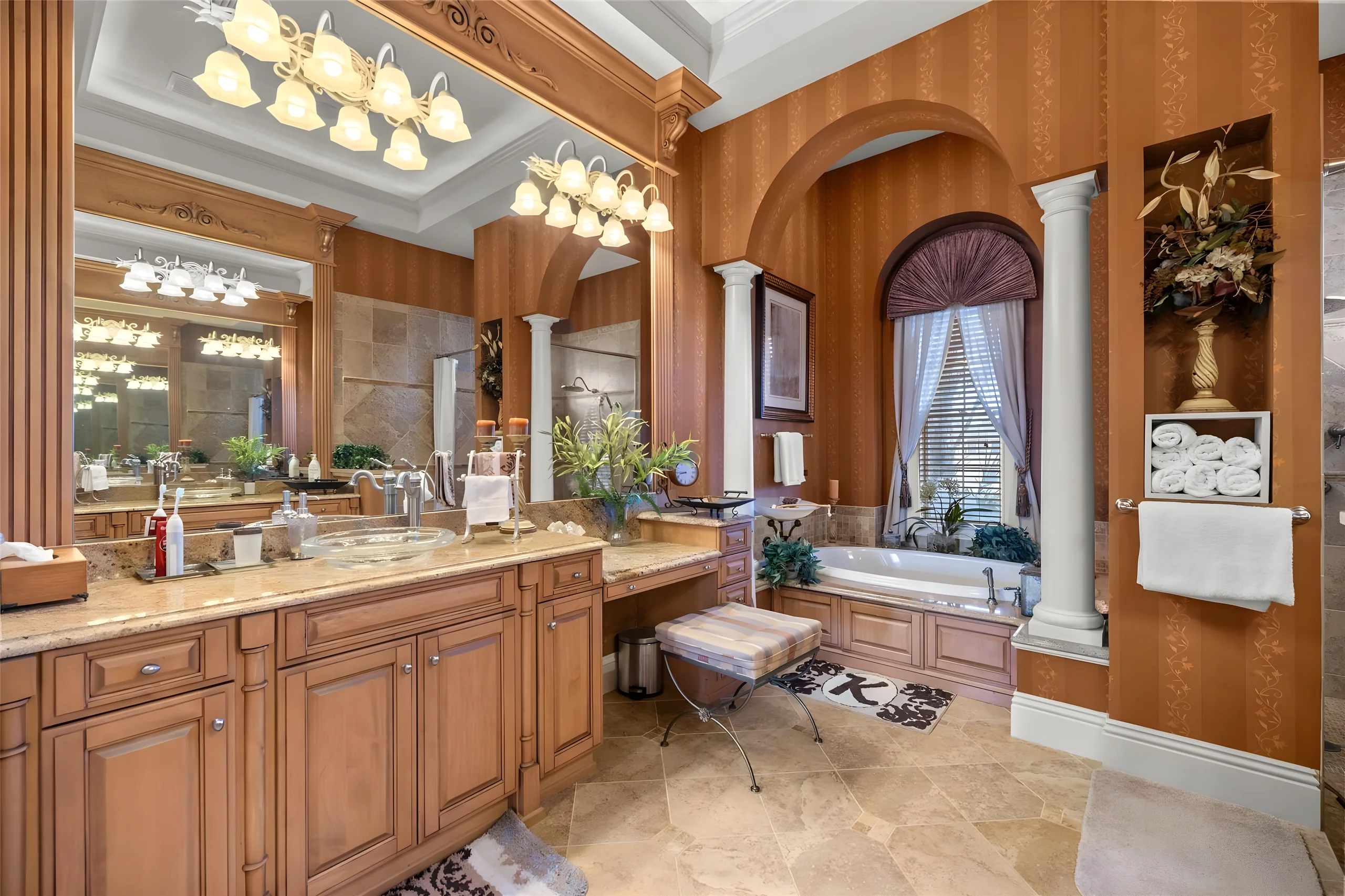 Master bathroom vanity with a makeup counter, and the jetted tub beyond between the columns