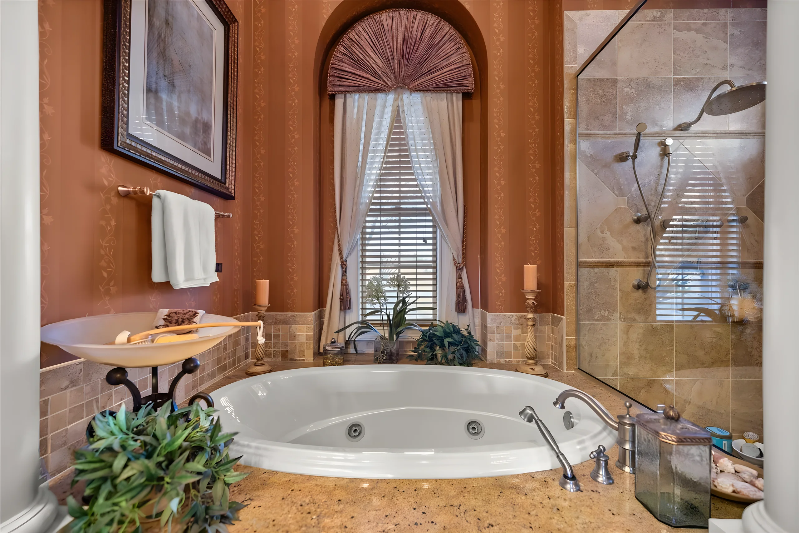 Jetted soaking tub under an arched window, with the walk-in shower beside it