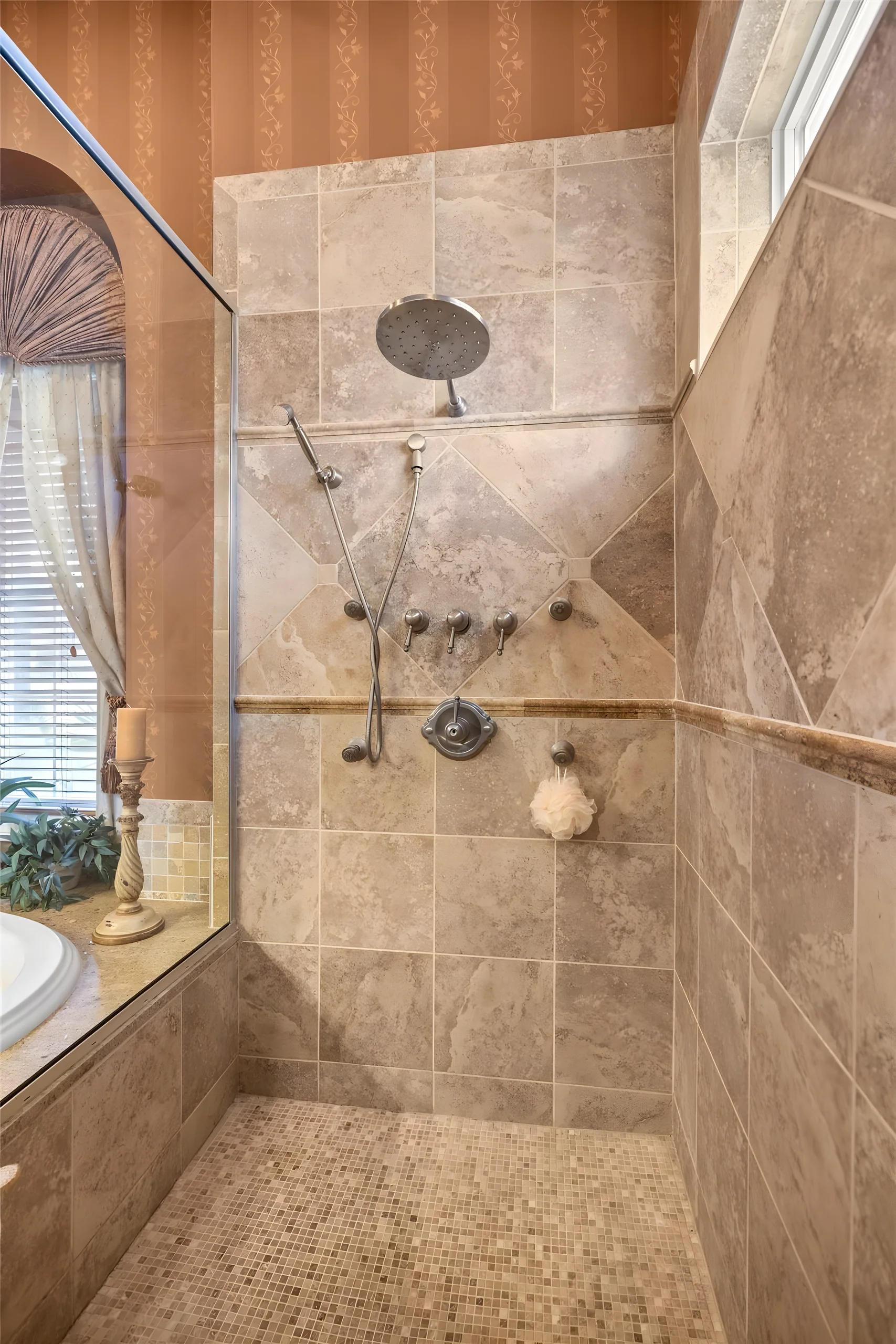 Walk-in shower with a rain head, body sprays and stone tile