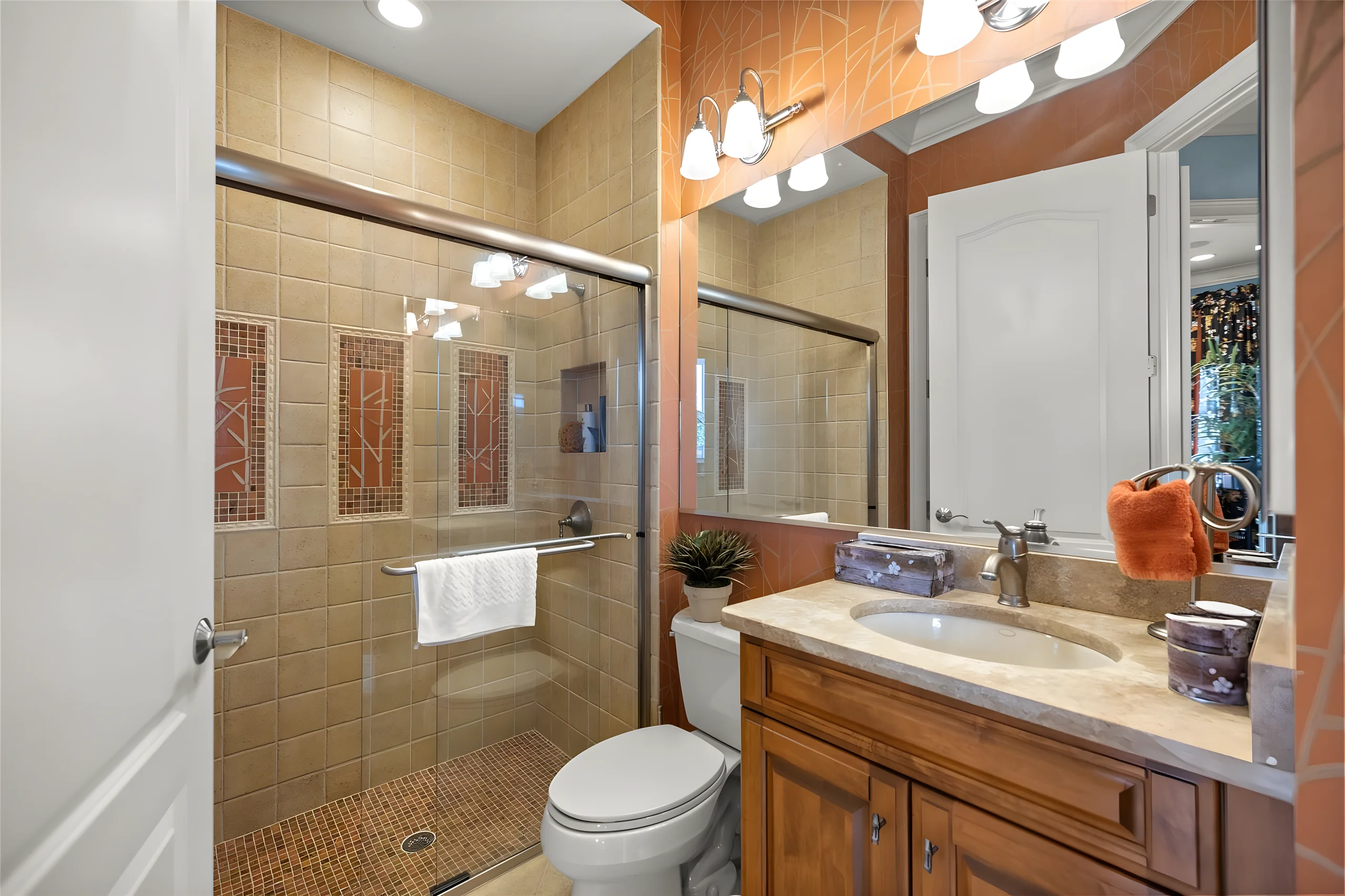 Pool bathroom with a glass shower, a wood vanity and tile walls
